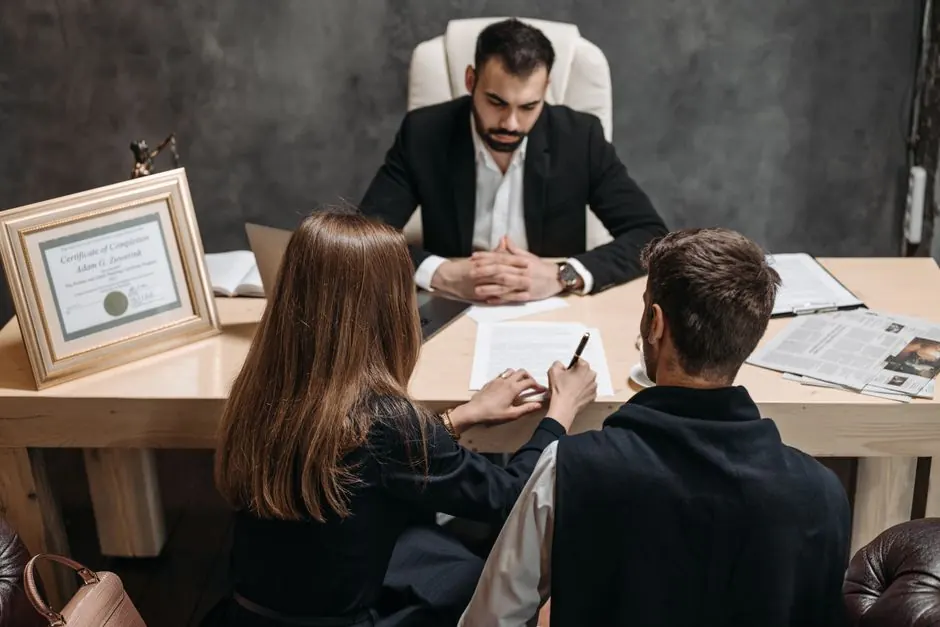 A lawyer discusses legal documents with clients in an office setting.