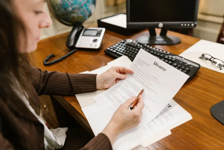 A lawyer examines divorce documents at a desk in a law office setting, emphasizing professionalism.
