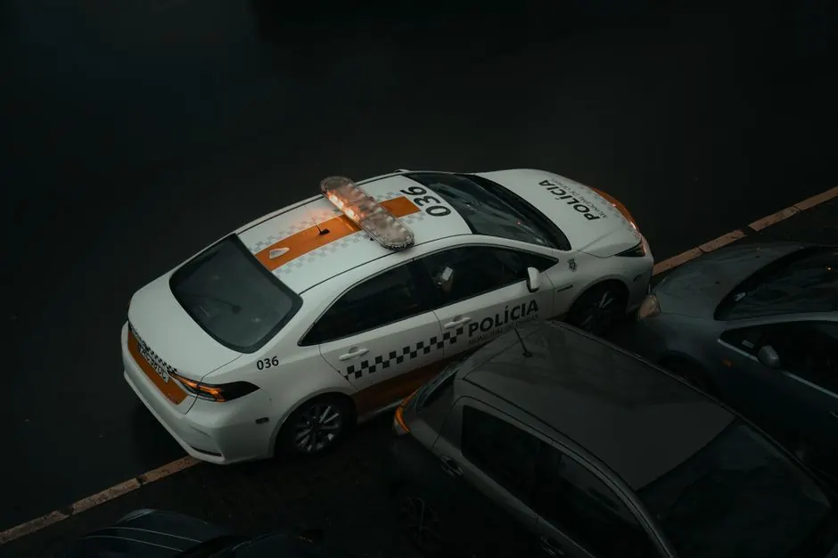 Aerial view of a police car parked on a street in Lisbon, Portugal, during the day.