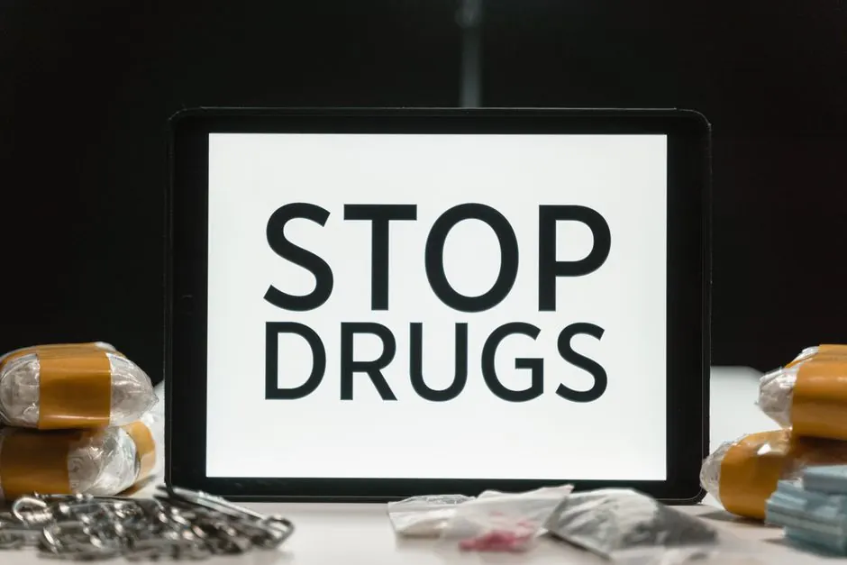Tablet screen displaying anti-drug message surrounded by packaged substances, promoting awareness.